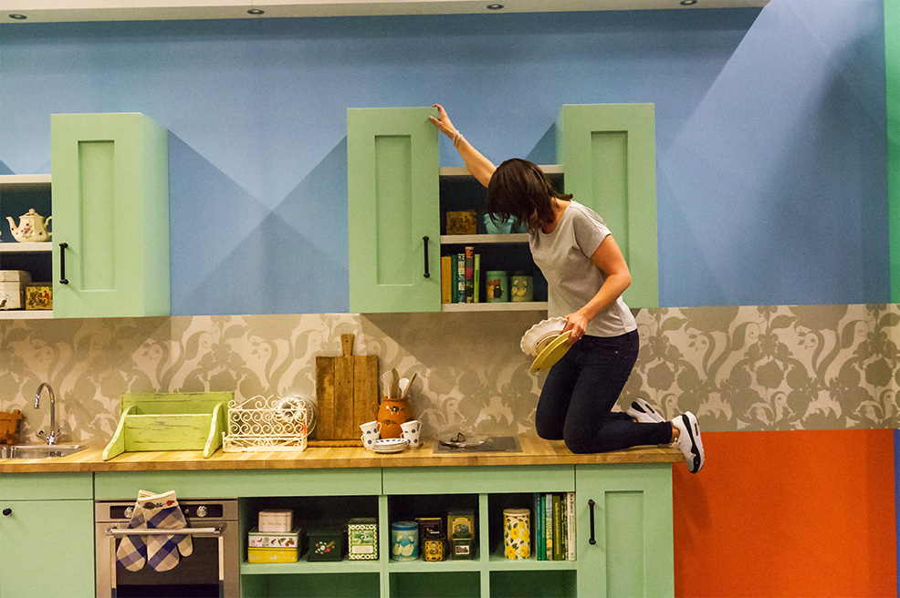 photo, set dresser Anouk going the extra mile, climbing the kitchen counter